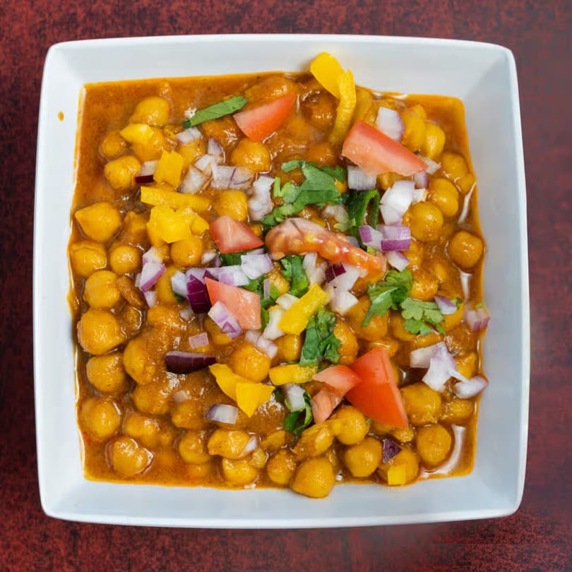 Masala Express Chana Masala, a chickpea curry, topped with diced tomatoes, onions, and cilantro.